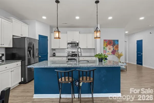 a kitchen with kitchen island a counter top space appliances and cabinets