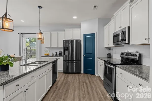 a kitchen with stainless steel appliances granite countertop a sink refrigerator and microwave