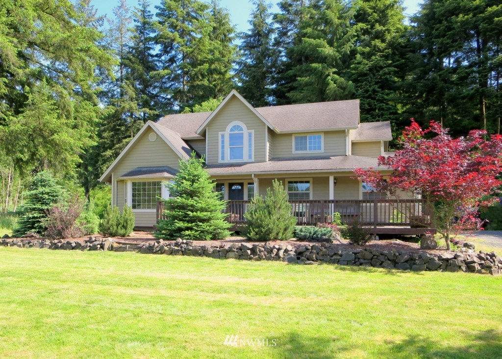a front view of house with yard and trees in the background