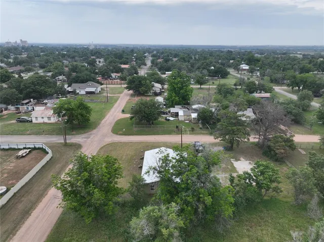 an aerial view of residential houses with outdoor space and trees