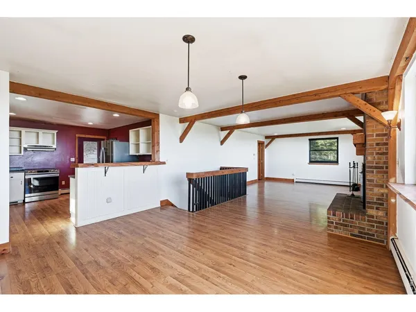 a kitchen with stainless steel appliances kitchen island granite countertop a stove a refrigerator and red cabinets