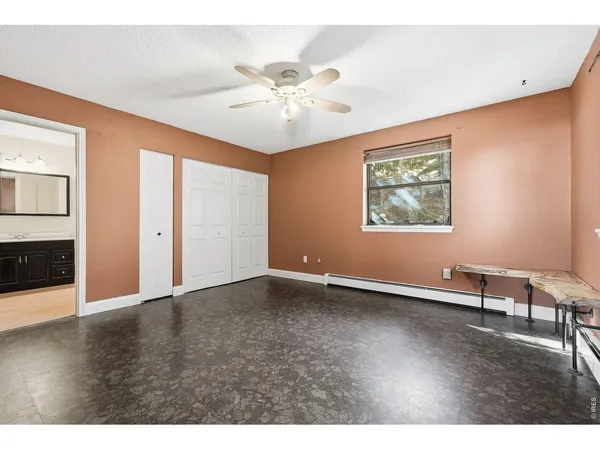an empty room with window and hardwood floor