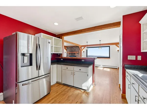 an empty room with window and hardwood floor