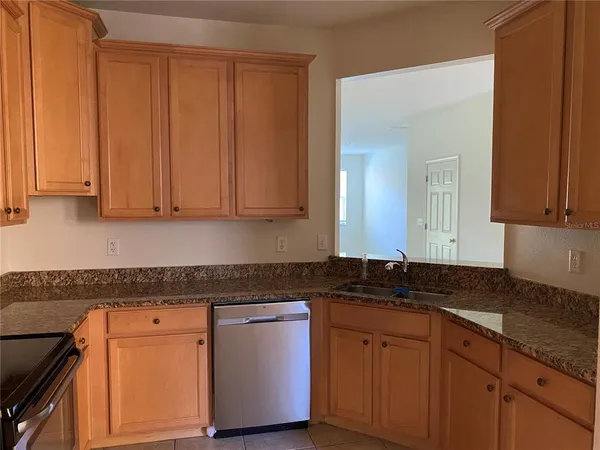 a kitchen with granite countertop white cabinets sink and dishwasher
