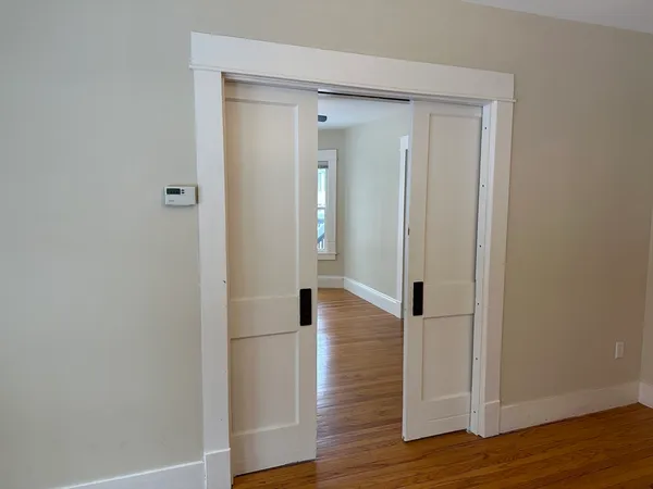 a view of a hallway with wooden floor