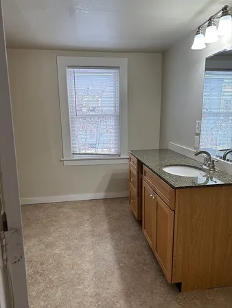 a kitchen with granite countertop a sink stove and cabinets
