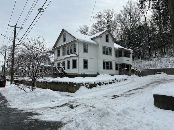 a front view of a house with a yard covered in snow
