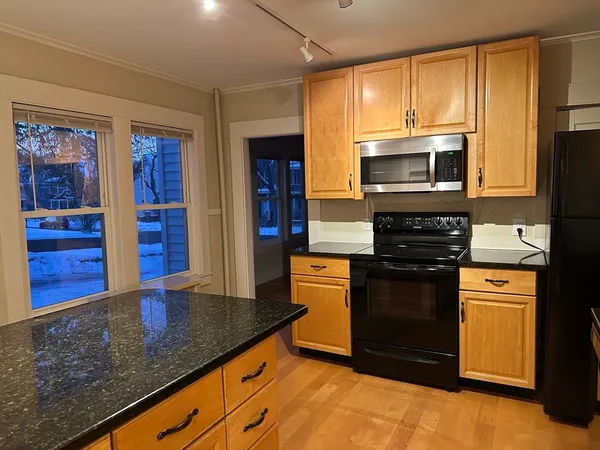 a kitchen with stainless steel appliances granite countertop a stove a microwave and a refrigerator