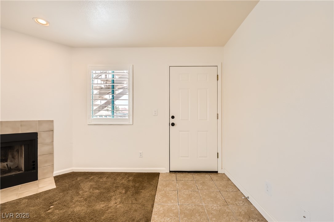 1575 West Warm Springs Road, Unit 1613 Henderson, NV 89014 - Photo 6 of 39 Entrance foyer with light tile patterned floors, baseboards, light carpet, and a fireplace