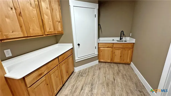 a hallway with washer and dryer with wooden floor