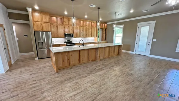 a large kitchen with a window and stainless steel appliances
