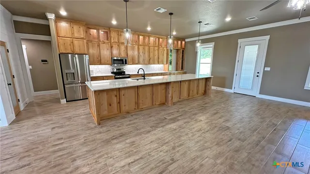 a kitchen with a sink and wooden floor