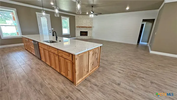 a kitchen with a sink and wooden floor