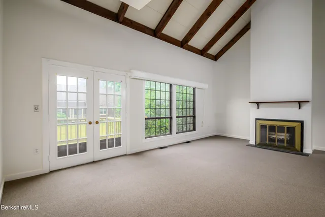 a view of an empty room with a fireplace and a window