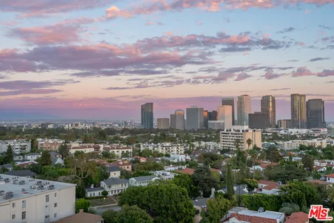 a spacious bedroom with a bed and a flat tv screen