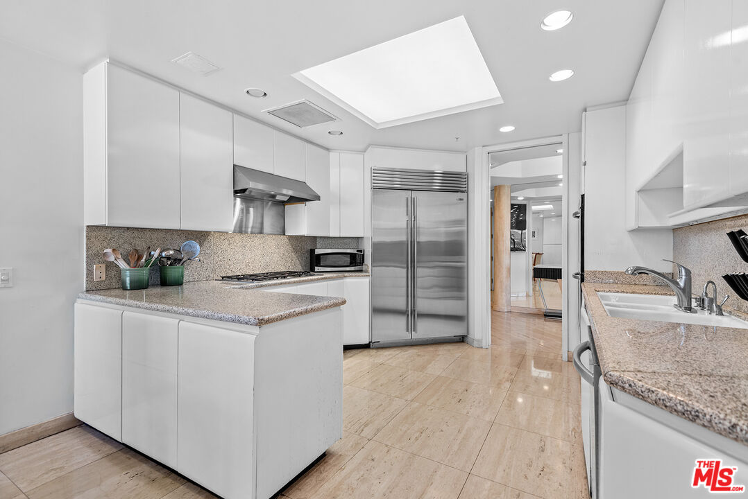10490 Wilshire Boulevard, Unit 1206 Los Angeles, CA 90024 - Photo 18 of 44 a kitchen with stainless steel appliances granite countertop a sink stove and refrigerator