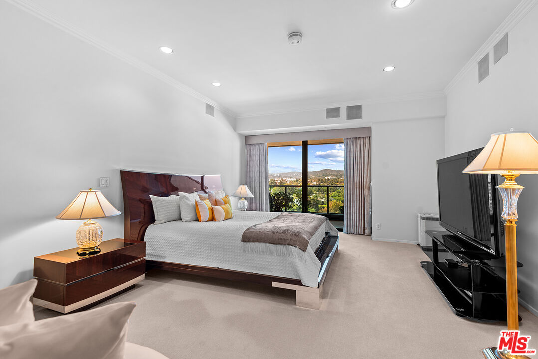 10490 Wilshire Boulevard, Unit 1206 Los Angeles, CA 90024 - Photo 23 of 44 a spacious bedroom with a bed and a flat tv screen