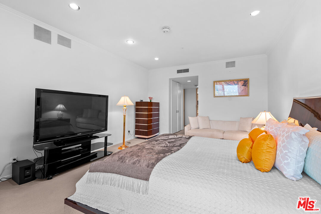 10490 Wilshire Boulevard, Unit 1206 Los Angeles, CA 90024 - Photo 24 of 44 a bedroom with a bed and a flat screen tv