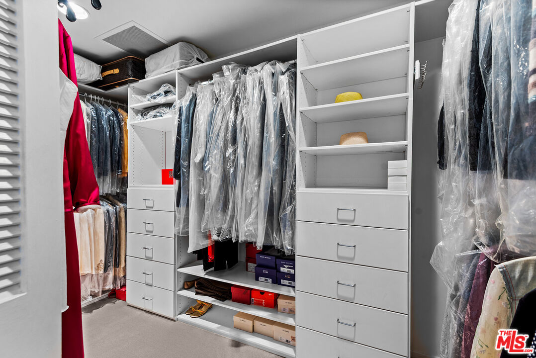 10490 Wilshire Boulevard, Unit 1206 Los Angeles, CA 90024 - Photo 25 of 44 a view of walk in closet with clothes and shoes
