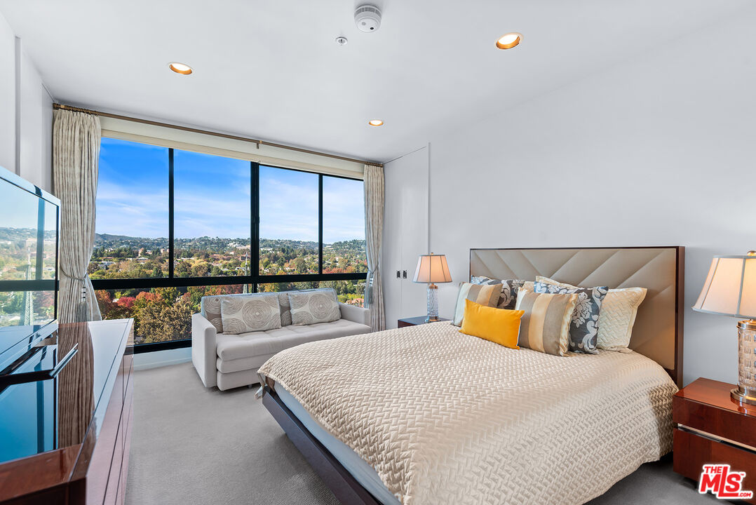 10490 Wilshire Boulevard, Unit 1206 Los Angeles, CA 90024 - Photo 27 of 44 a bedroom with a large bed and large windows