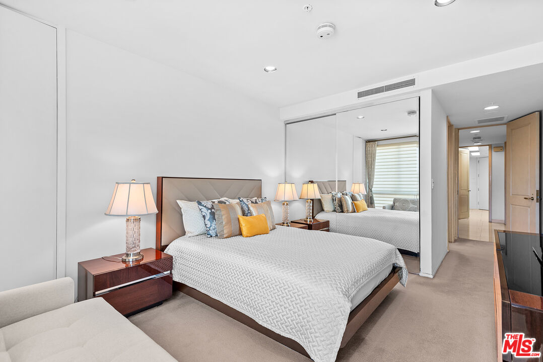 10490 Wilshire Boulevard, Unit 1206 Los Angeles, CA 90024 - Photo 29 of 44 a bedroom with a bed and a lamp