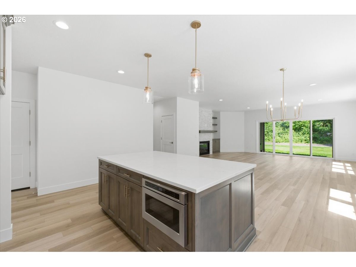 2147 Northeast Spitz Road Canby, OR 97013 - Photo 11 of 48 a kitchen that has a wooden floor and white cabinets