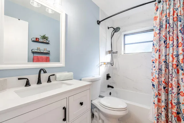 a bathroom with a sink toilet a mirror and shower