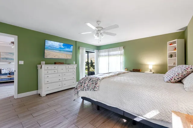 a bedroom with a bed dresser and wooden floor
