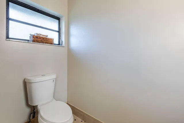 a white toilet sitting next to a white cabinet