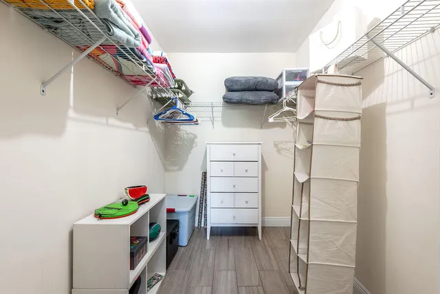 a view of walk in closet with clothes and shoes