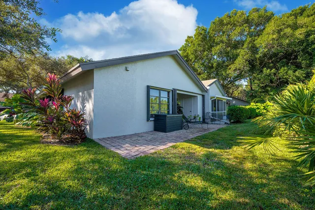 a view of a house with a patio and a yard
