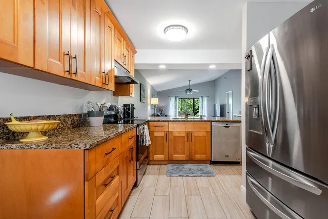 a kitchen with stainless steel appliances granite countertop a refrigerator a sink and dishwasher