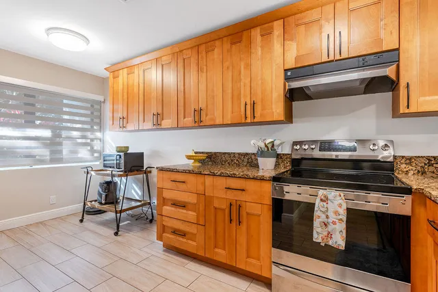 a kitchen with stainless steel appliances granite countertop a stove and a sink