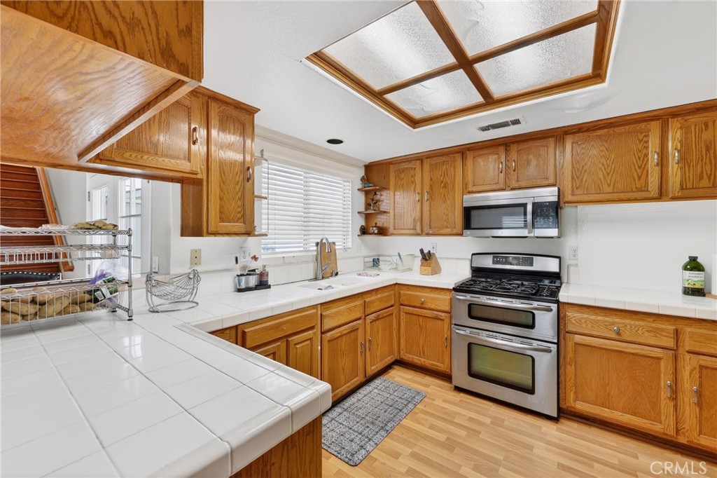 10939 Little Lake Road Downey, CA 90241 - Photo 13 of 55 a kitchen with stainless steel appliances a stove sink and cabinets