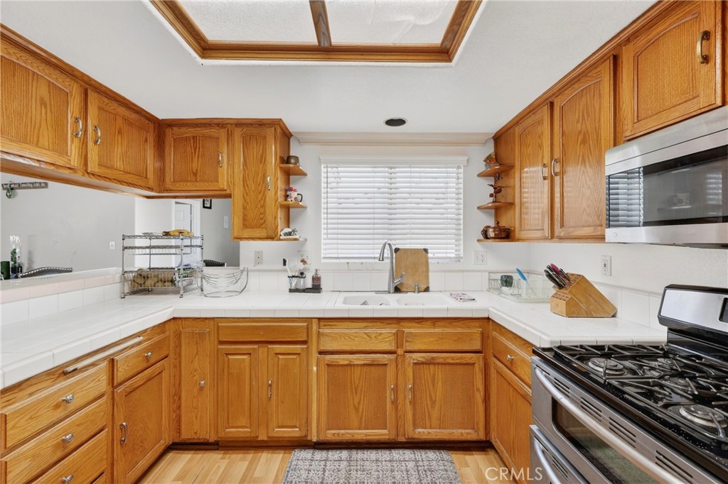 10939 Little Lake Road Downey, CA 90241 - Photo 10 of 55 a kitchen with stainless steel appliances granite countertop a sink stove and cabinets