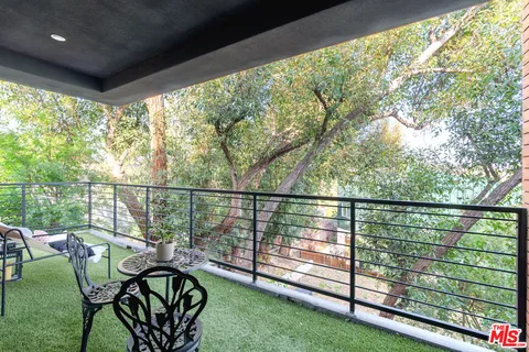 a view of a balcony with wooden floor and outdoor seating