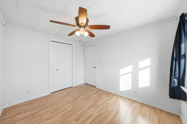 a view of a big room with wooden floor and a chandelier fan in a room