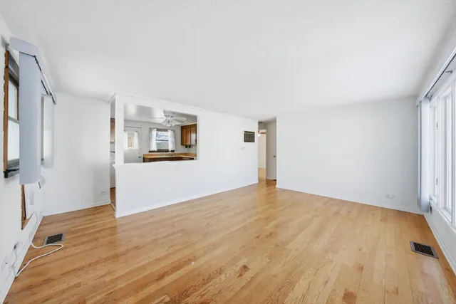 a view of a big room with wooden floor and a kitchen