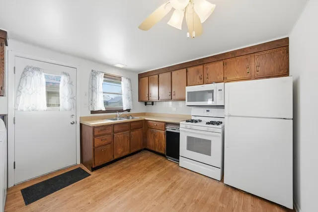 a kitchen with a sink white cabinets and white appliances