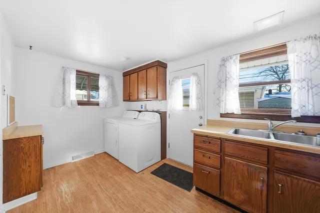 a room with a sink cabinets and a window