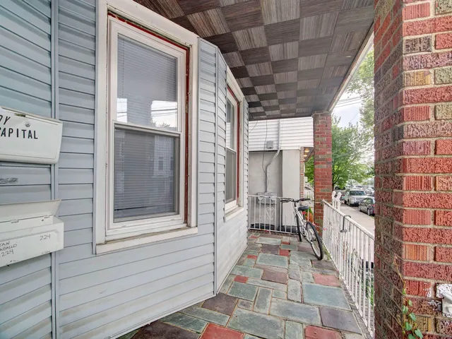 a view of a porch with a door and wooden floor