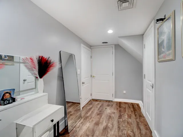 a view of a hallway with workspace and wooden floor