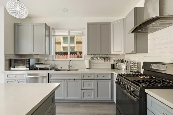 a kitchen with cabinets appliances a sink and a window