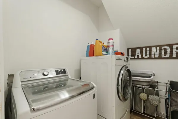 a utility room with dryer washer and a view of living area