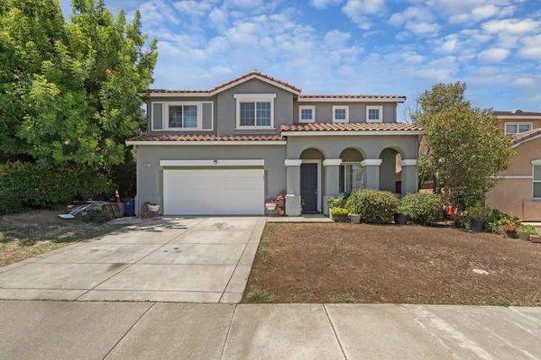 a front view of a house with a garden and garage