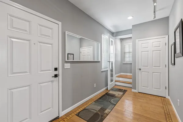 a view of a hallway with wooden floor and windows
