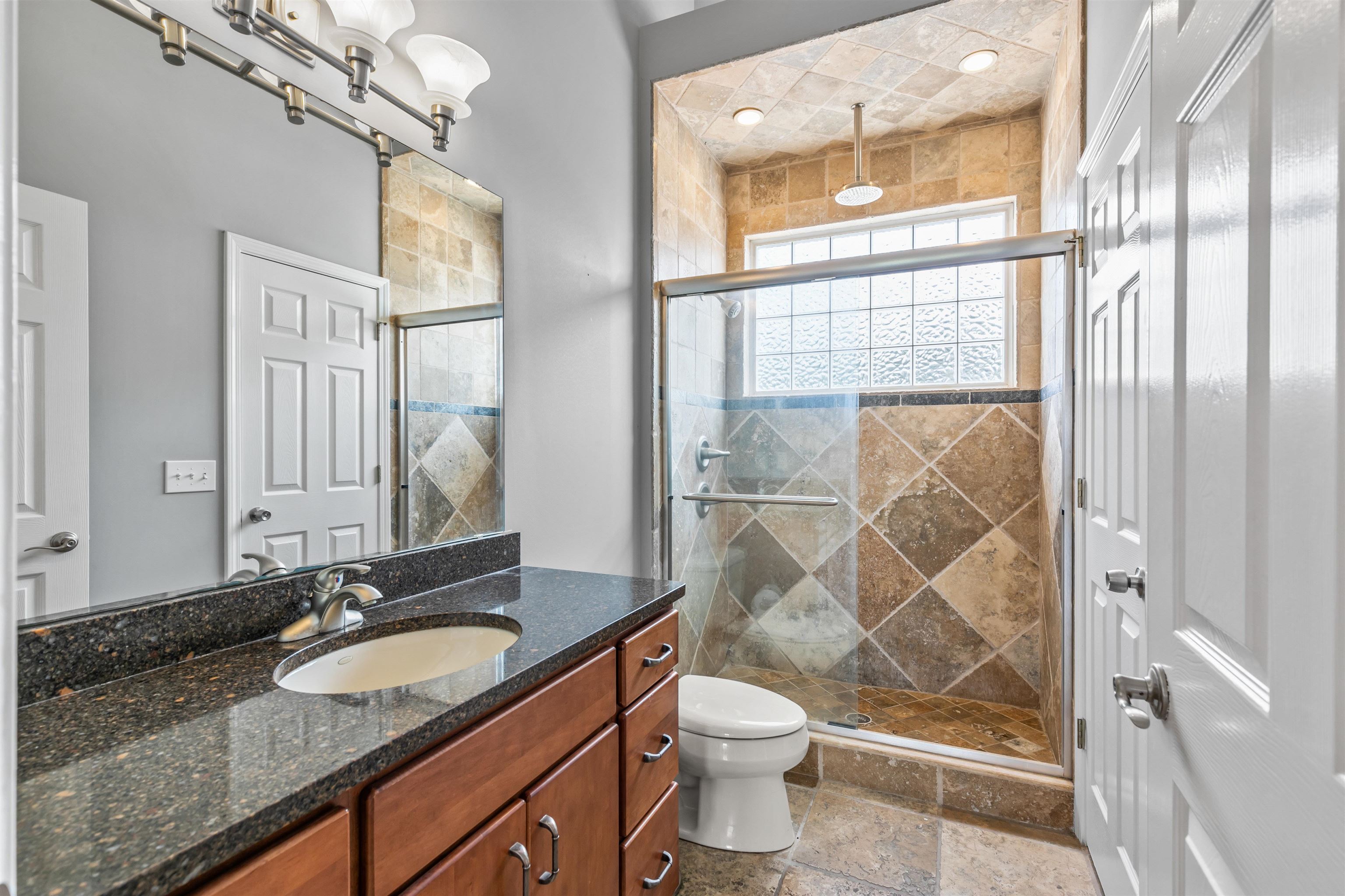 28 Spring Street St. Augustine, FL 32084 - Photo 33 of 36 a bathroom with a granite countertop sink toilet and shower