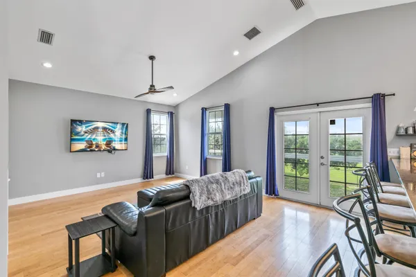 a kitchen with granite countertop stainless steel appliances a refrigerator a stove top oven and a dining table with wooden floor