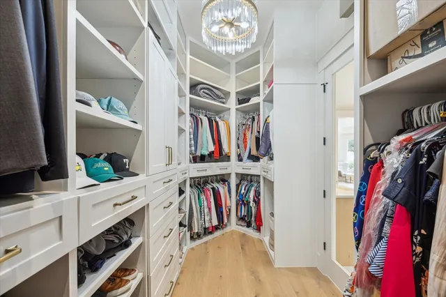 a view of walk in closet with clothes and shoes