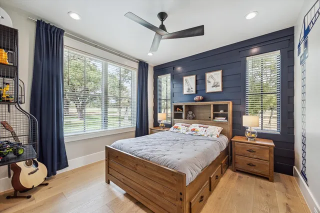 a bedroom with a bed and large windows